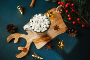 Warm cocoa drink with marshmallows and spices on wooden deer shaped tray winter holiday still life