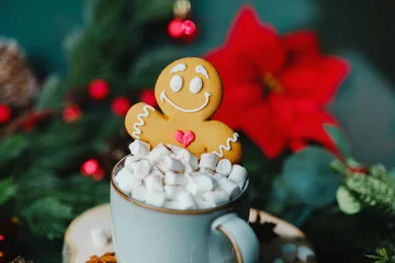 Fototapete Rund Schokolade Christmas gingerbread man cookie sits on marshmallow hot chocolate drink near festive evergreen branches  © reddish