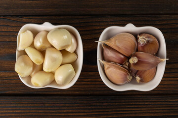 Fresh and Unpeeled Garlic Cloves in Ceramic Bowls on Rustic Wooden Table