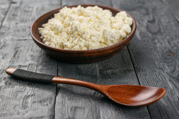 Rustic Wooden Bowl with Fresh Cottage Cheese on Weathered Wooden Table