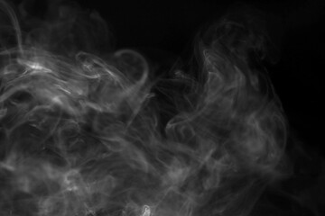 Obraz premium Abstract smoke swirls and patterns against black background, evoking a sense of mystery and depth. The delicate tendrils of smoke create an ethereal and dynamic visual effect