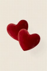 Two red velvet hearts float softly, creating a warm and inviting aesthetic against a subtle grid background