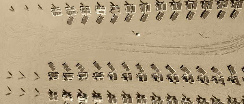 Aerial drone view of a seaside beach resort with colorful umbrellas and summer vacation atmosphere