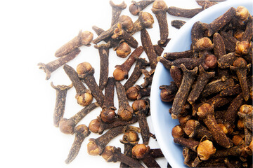 Dried aromatic clove spice in white bowl close up