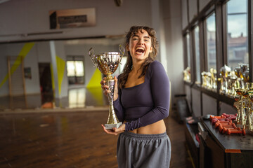 Young woman proudly holding trophy celebrating victory
