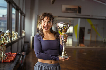 Young woman proudly holding trophy celebrating victory