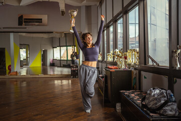 Young woman proudly holding trophy celebrating victory