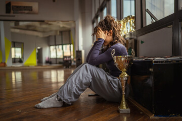 Young female athlete feeling sad and disappointed after competition