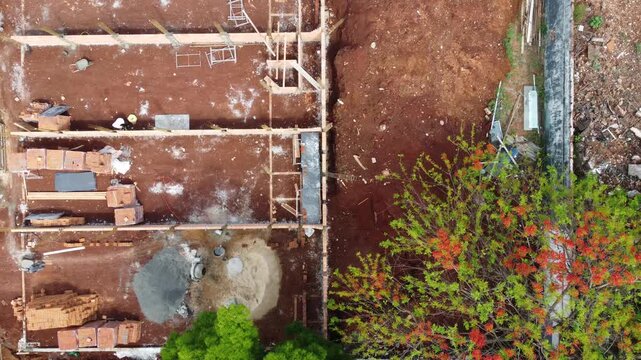 Drone top-down shot of a construction site with brick wal