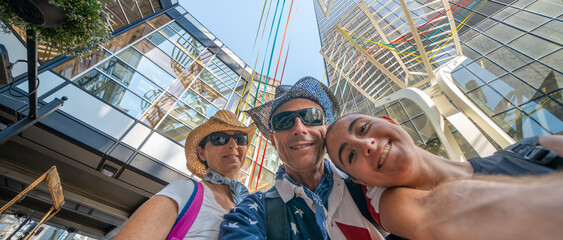 Family of three people take selfie with skyscrapers background, skyward view