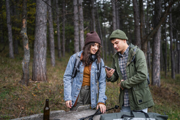 Couple checking smart phone trail map during forest hiking