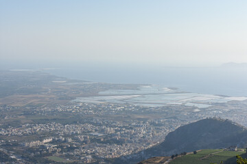 Fototapeta premium Saline Di Trapani saltworks, view from Erice. Scenic panoramic view from Erice town at sea coast in Sicily, Italy, Europe. The Mediterranean Sea. Vacation in Sicily. Travel to Italy. Summer. 