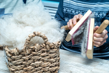 The skill of carding wool by hand, is crucial for producing quality yarn.