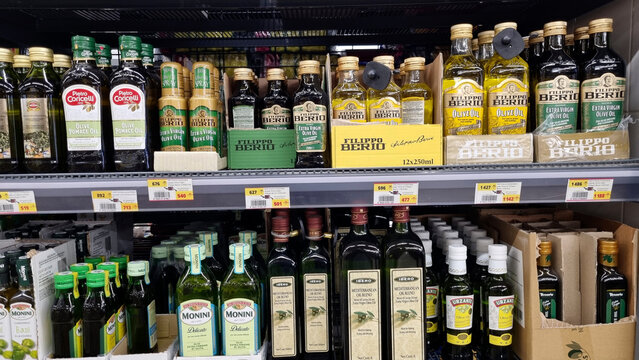 A supermarket shelf with a selection of olive oils from various brands.
 