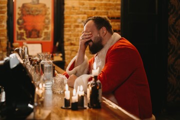 Stressed santa covering face at dimly lit bar