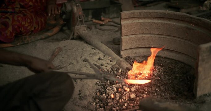 Cinematic shot of Indian blacksmiths forging tools like hoe, sickle, and  spade in a workshop
