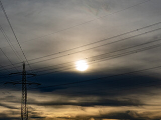 Hochspannungsmasten unter einem bizarren Wolkenhimmel

