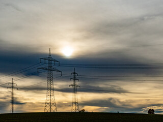 Hochspannungsmasten unter einem bizarren Wolkenhimmel
