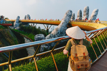 Tourist with backpack exploring golden bridge in ba na hills, Da nang, Vietnam travel trip concept