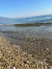 Close-up of Clear Sea Water Rippling Over Fine Gravel Beach Shoreline