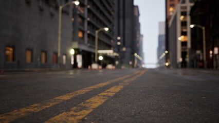 Quiet urban street revealing deserted pathways at dawn. The soft glow of streetlights contrasts with tall buildings, creating a serene atmosphere. A moment of peace before daily activity begins.
