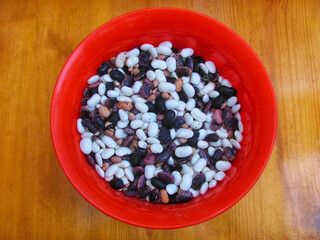 Assortment of dried beans in a red bowl