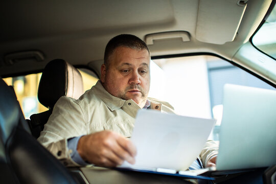 Mature man working on laptop in car