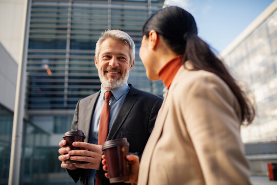 Mature business professionals having coffee outdoors