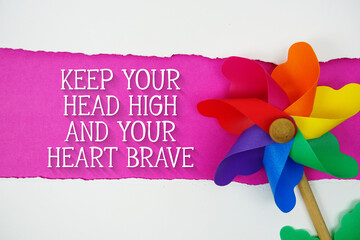 Keep Your Head High and Your Heart Brave motivational and inspirational quotes message on pink...