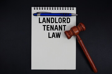 Landlord Tenant Law text written on notepad with gavel on black background