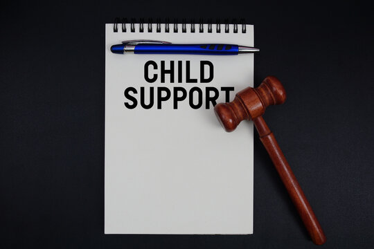 Child Support text written on notepad with gavel on black background