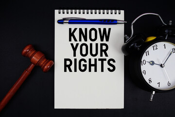 Know Your Rights text written on notepad with gavel and alarm clock on black background