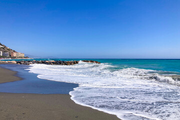Stormy Mediterranean Sea with deep blue waves crashing on the sunny beach in Almunecar, Andalusia, Spain.