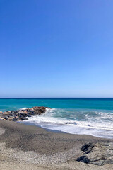 Stormy Mediterranean Sea with deep blue waves crashing on the sunny beach in Almunecar, Andalusia, Spain.