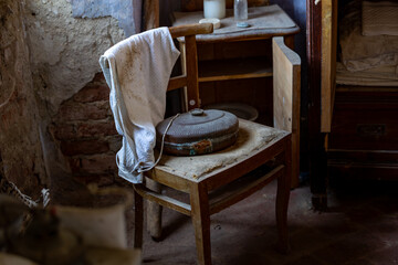 Vintage Metal Bed Warmer on Wooden Chair in Rustic Abandoned Interior