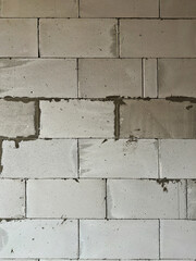 Textured unfinished concrete block wall in neutral gray tones, with rough blocks and visible mortar joints for an industrial construction vibe