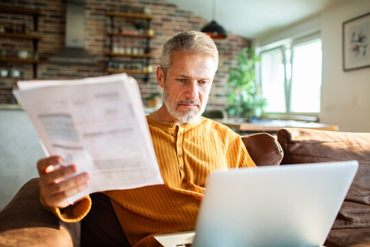 Mature man working on laptop at home