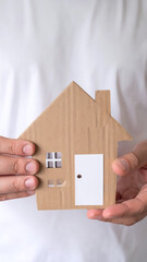 Person holding a cardboard house against a transparent background