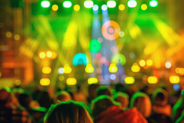 Blurred view of colorful concert stage with bright lights and crowd silhouettes during night event. Abstract background. Concept of music festival, party atmosphere, nightlife entertainment