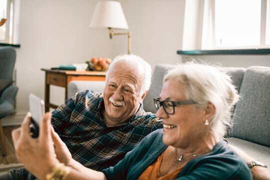 Senior couple taking selfie at home - Powered by Adobe