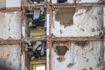 Crumbling structure exposing building interior and pipes.