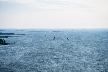 Obraz premium Overcast view of coastal inlet with scattered boats.