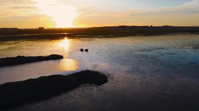 imagen a&eacute;rea de dos vacas atravesando una laguna al atardecer en las llanuras de los palmares del norte de Uruguay