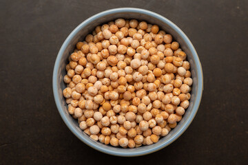 Chickpeas in a blue bowl on a black background. Top view of a bowl of chickpeas