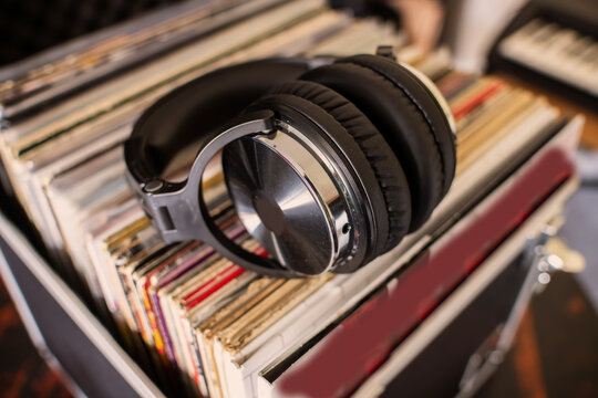 Analog music nostalgia with LP records and padded black headphones.