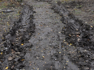 Dirt road with deep tire tracks in mud
