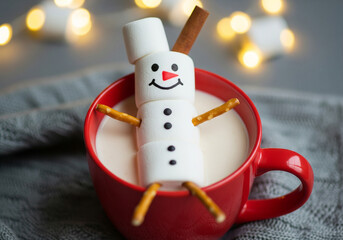 Marshmallow snowman relaxing in a mug of hot chocolate on a cozy winter day. A whimsical marshmallow snowman takes a warm bath in a mug of hot chocolate, perfect for wintertime enjoyment