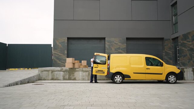 Delivery man unloading cardboard boxes from yellow van