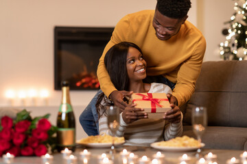 A black husband surprises his wife with a Valentine gift while they enjoy a romantic candlelight...