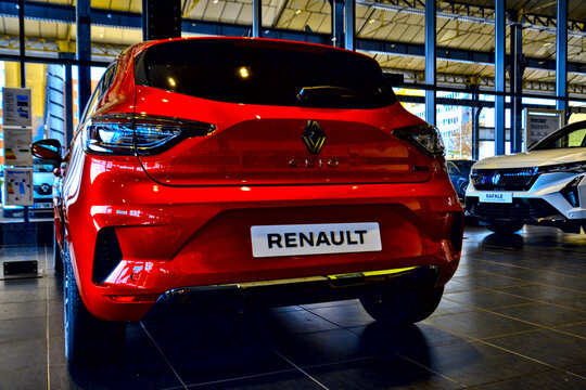 Saint-Etienne, France - February 13th 2025 : Rear view of a red Renault Clio in the showroom, highlighting its modern hatchback design, sleek lines, and innovative electric or hybrid features.